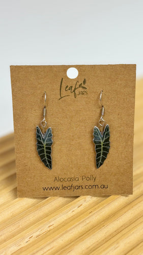 Alocasia Polly Leaf Earrings sitting on timber board