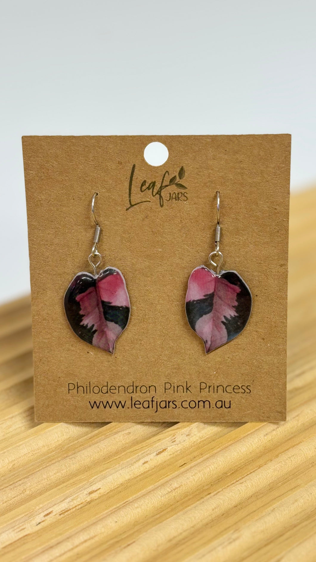 Philodendron Pink Princess Leaf Earrings on timber board